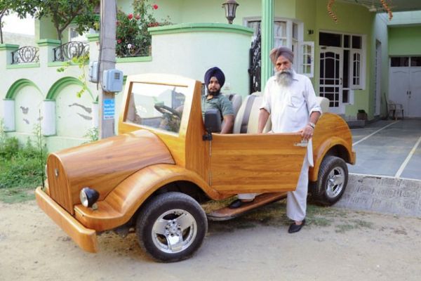 Mohinder Singh Lotay (dir) exibe ao lado do filho Amandeep Singh Lotay o carro de madeira