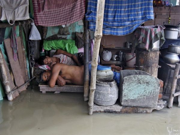 Moradores dormem de maneira improvisada depois do nvel das guas do rio Ganges subir em Kolkata, na ndia