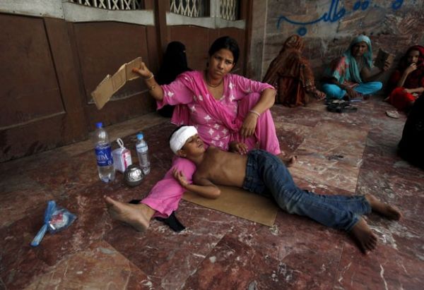 Mulher abana filho do lado de fora de hospital em Karachi, no Paquisto, nesta tera-feira (23), em meio a onda de calor que j matou centenas de pessoas no pas