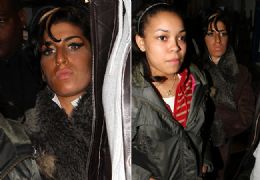 Amy Winehouse tropea e cai de joelhos na porta de hotel