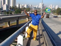 Vendedor se acorrenta   uma ponte estaiada para apoiar o Brasil na Copa
