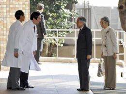 mperador japons, Akihito, e sua mulher, a imperatriz Michiko, so recebidos pelos mdicos na entrada da Universidade de Tquio, no sbado (18).