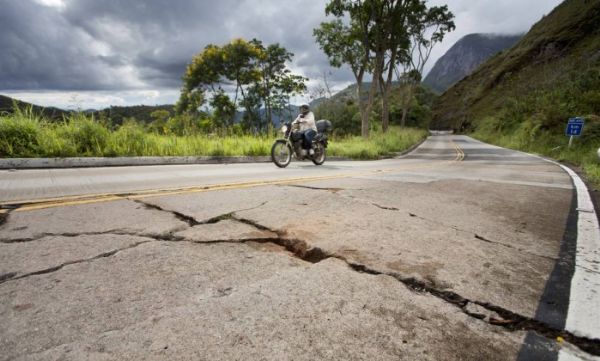 Pavimento comprometido: Motoqueiro passa pelo km 14 da BR-495, na Regio Serrana do Rio: concreto da pista est rachado e eroso se estende pela pista