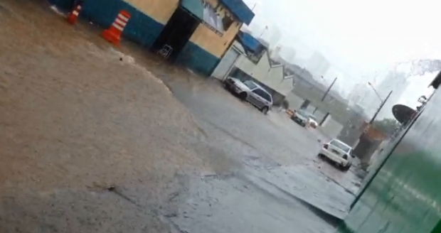 Chuva carrega esgoto para dentro de comrcios em cruzamento interditado pela Defesa Civil; vdeo 