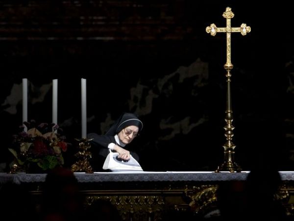 Freira usa ferro de passar para preparar altar para a chegada do papa Bento XVI antes de missa no Vaticano