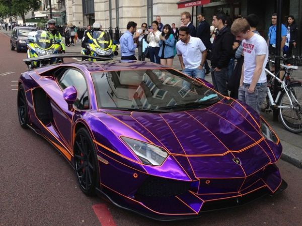 Juntiy gente para ver o Lamborghini roxo parado em rua de Londres