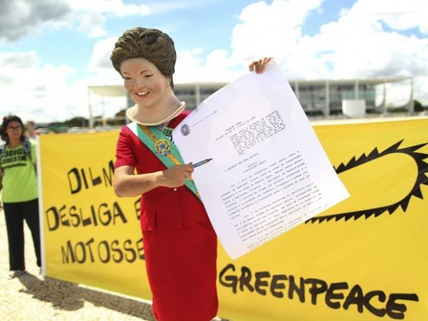Ator vestido de Dilma Rousseff simula a presidente assinando o veto no Cdigo Florestal, em frente ao Palcio do Planalto, em Braslia.
