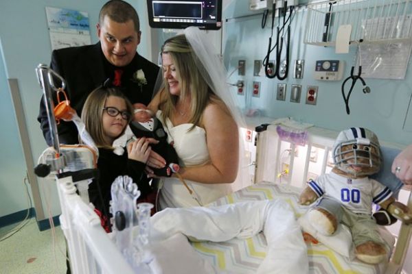 A famlia Warriner posa durante o casamento de Kristi e Justin na UTI neonatal onde o filho deles, J.J, est internado nos EUA