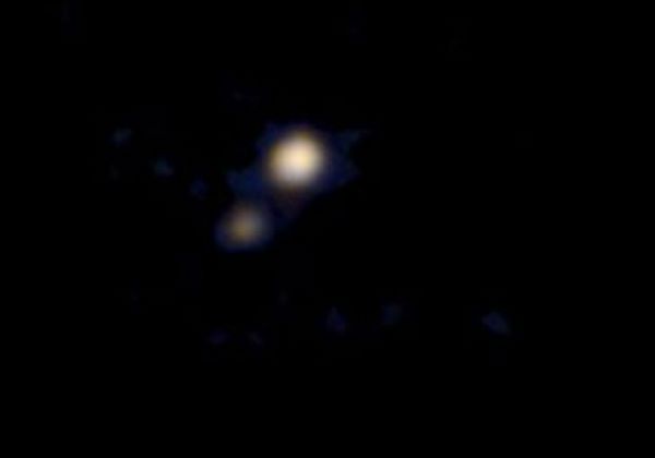 Fotografia revela que Caronte, a lua de Pluto ( esquerda),  mais escura que o planeta